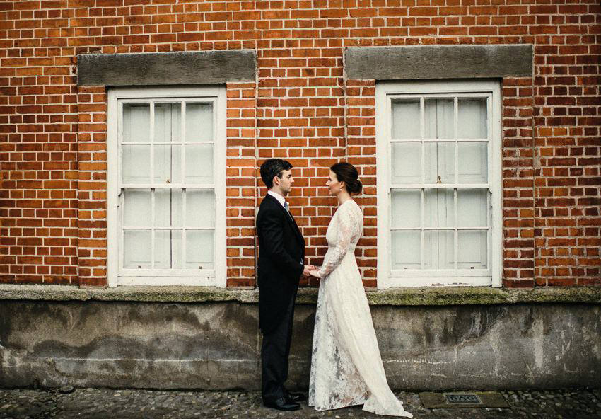 bride and groom at front of red brick building